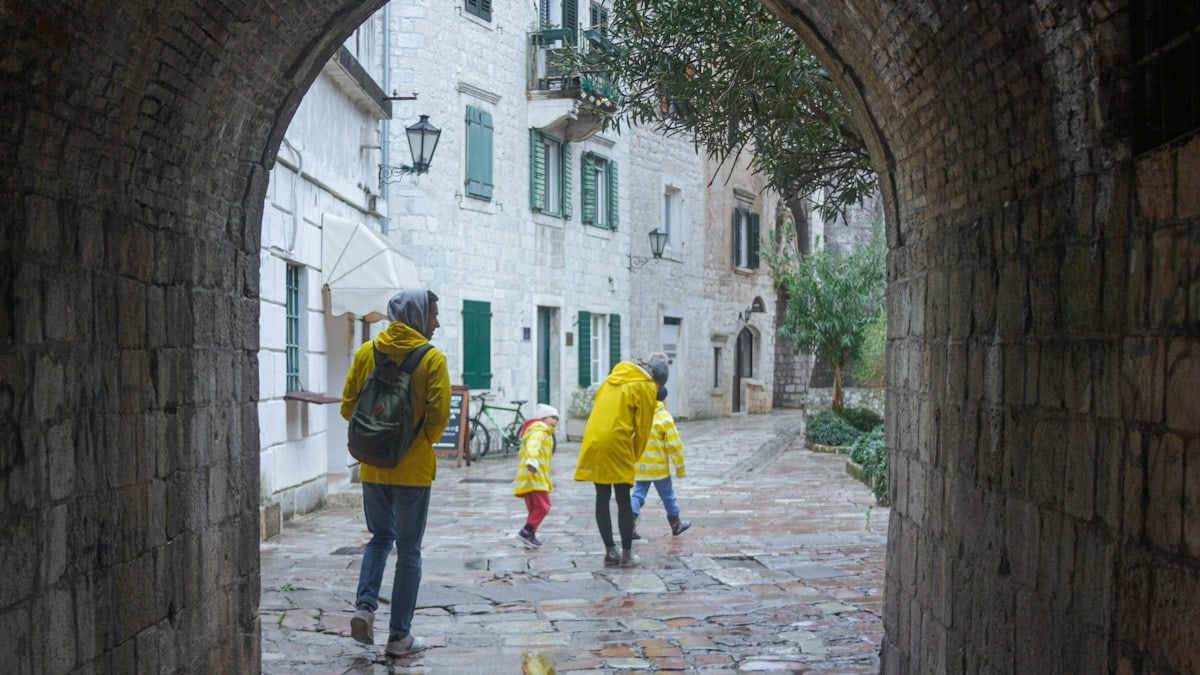 a group of people walking down a cobblestone street